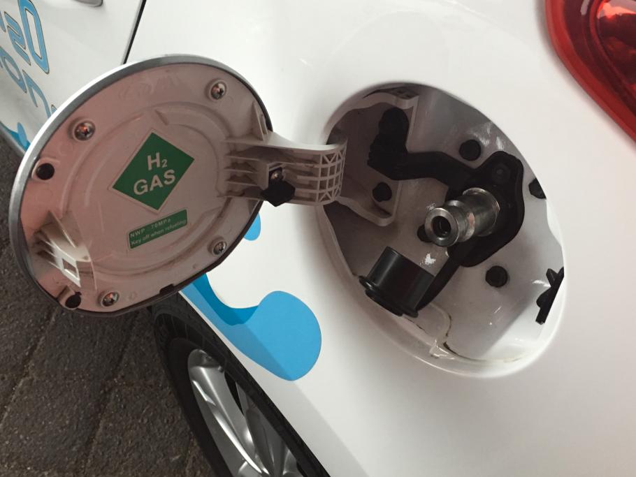 A photo of refueling a hydrogen fuel cell car, with H2 on the gas cap.