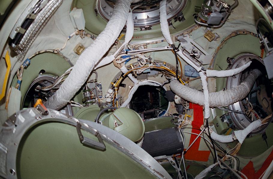 View inside the Mir space station, wires and cords are visible from one module to the next. 