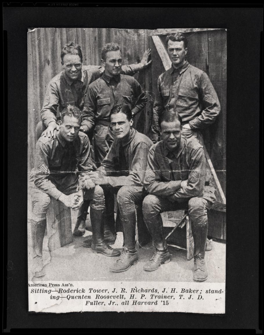 Three men stand behind three men sitting, all in uniform
