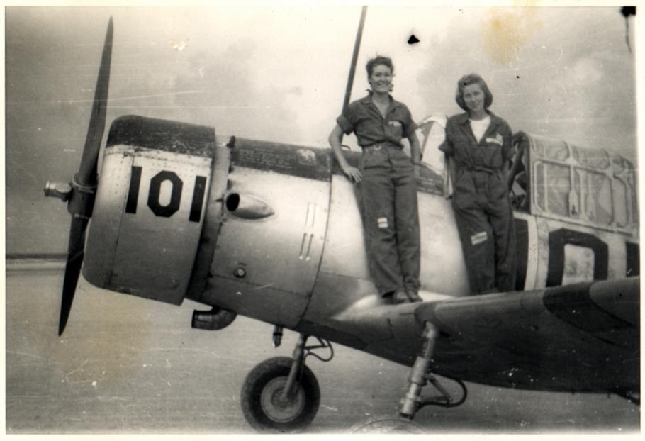 two women stand on wing of aircraft