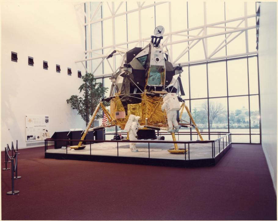 Lunar Module with protective railing on red carpet.
