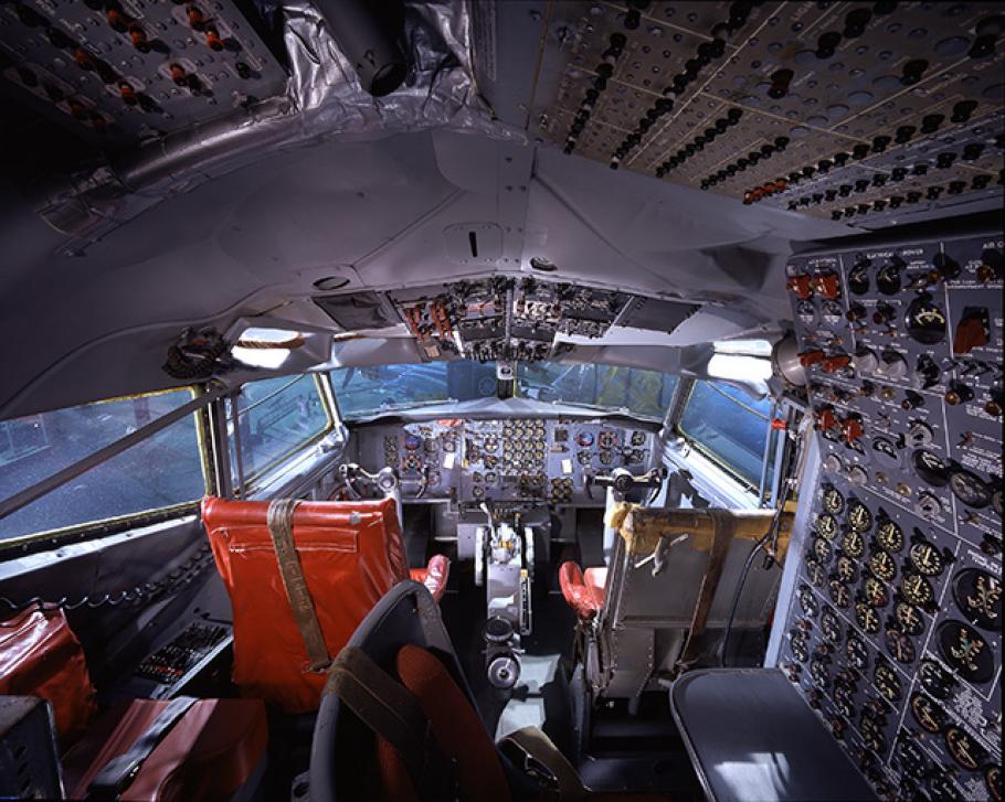 The cockpit of plane, including two seats and countless nobs and switches. 