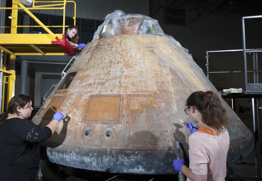 Conservators work on the Command Module Columbia