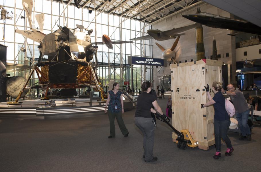 Gene Cernan's Apollo 17 spacesuit being moved out of the exhibit case in the "Apollo to Moon" gallery