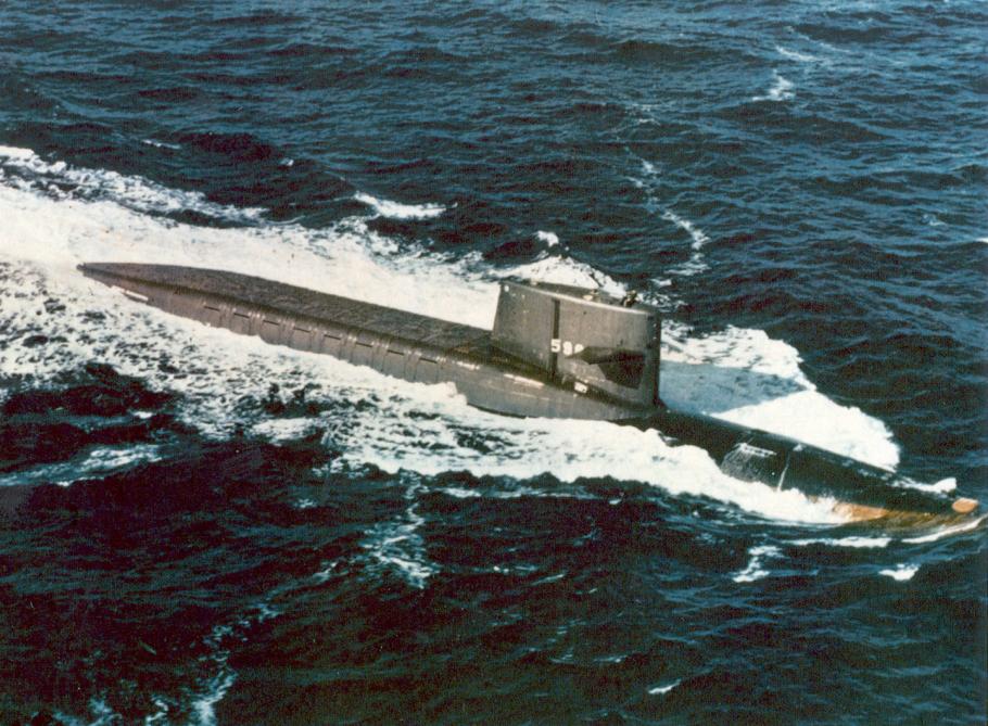 Top of a submarine pokes up from the water. 