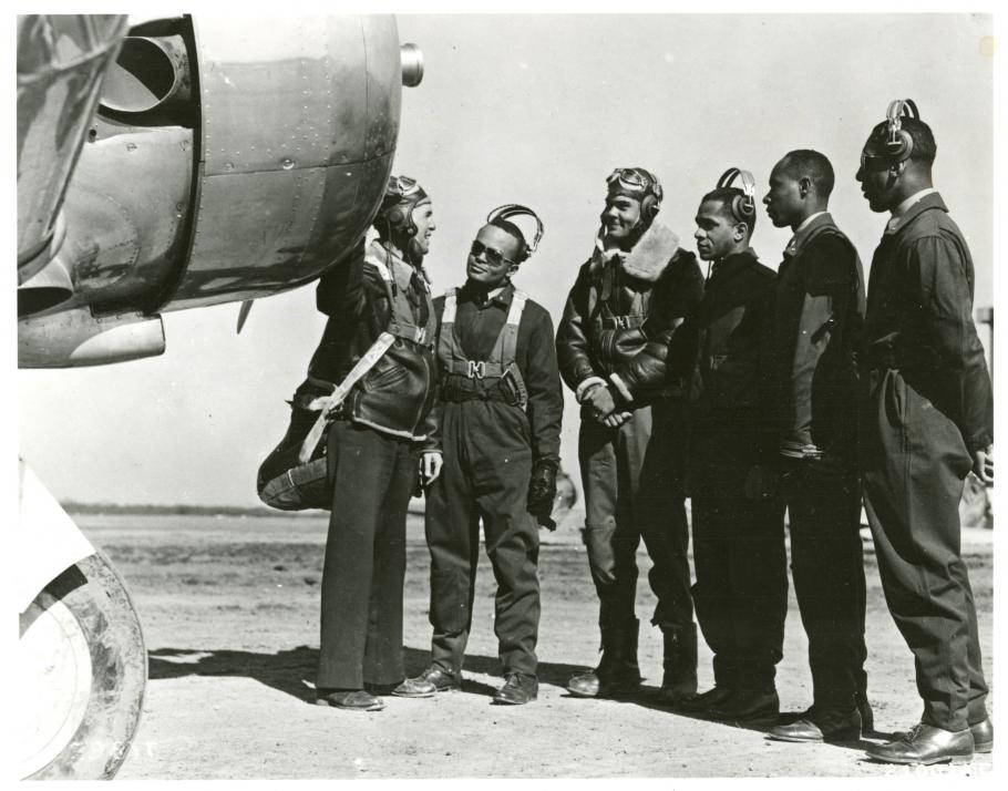 Five men look at an airplane