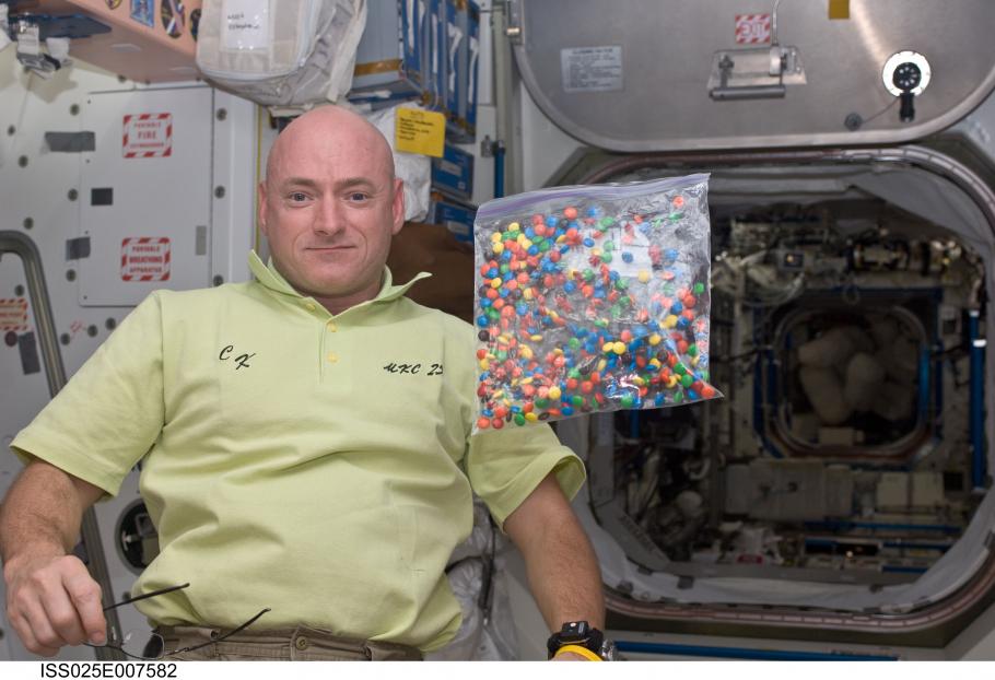 A photo of NASA engineer Scott Kelly with a bag of candy aboard the International Space Station.