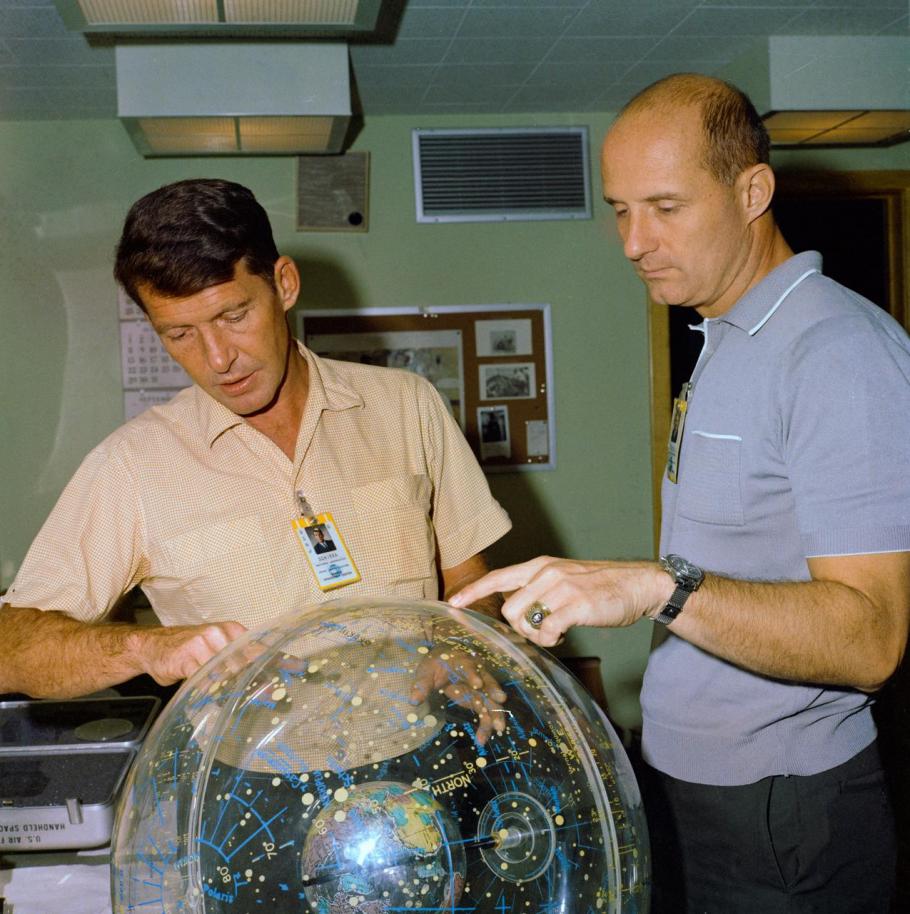 Astronauts Wally Schirra and Thomas Stafford, examine a star globe ahead of their upcoming Gemini VI mission