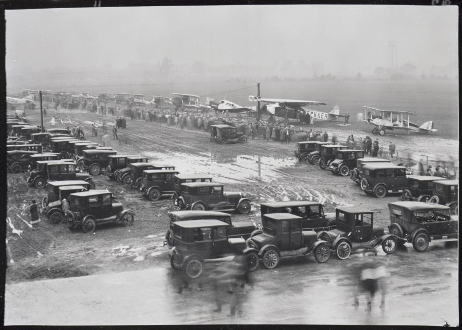 High level view of aircraft participating in the first Ford Commercial Airplane Reliability Tour lined up in rainy weather at the edge of the field 
