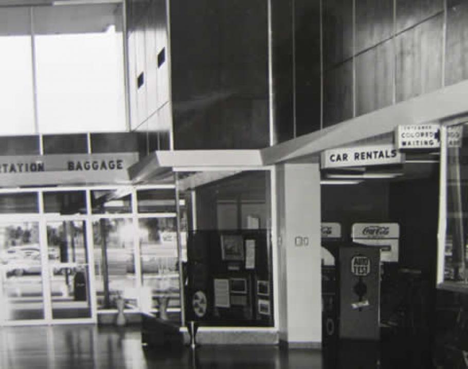 Image of the airport waiting room that shows a sign on right to a sitting area for African Americans.
