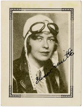 A woman with a pilot's helmet on stares at the camera. 