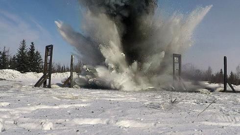 An ordnance disposal explosion in snowy landscape
