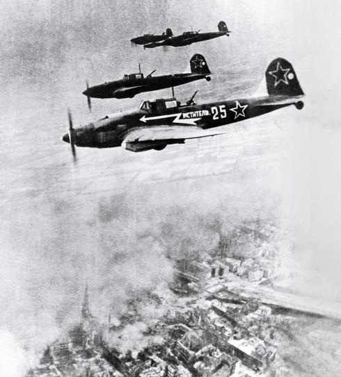 Three Soviet IL-2 ground attack aircraft fly over Berlin in 1945.
