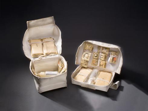The Apollo 11 lunar module medical kit is two separate bags, opened to reveal their contents, which include bandages and pharmaceuticals.