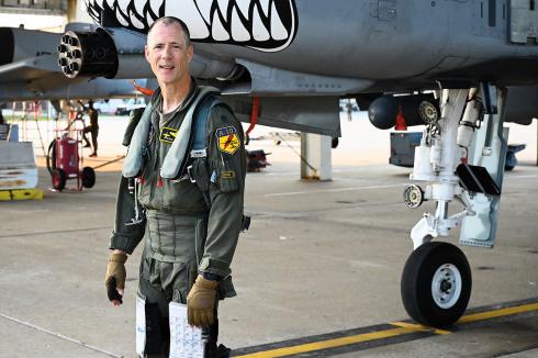 Colonel John “Karl” Marks of the U.S. Air Force Reserve stands in front of a Fairchild Republic A-10C Thunderbolt II, which boasts a shark’s grin painted above its powerful guns.
