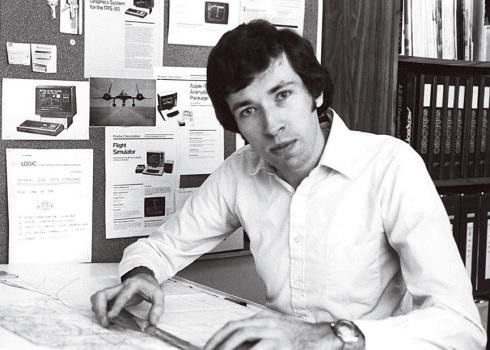 A 1980 photo of programmer Bruce Artwick includes a corkboard covered in ads and images depicting early home computer.