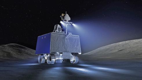 A pair of lights mounted on the box-shaped rover illuminates the immediate surroundings in the pitch black lunar dark.