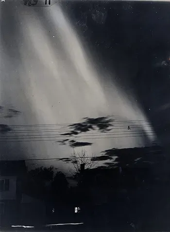 Faded vintage image of the night sky illuminated by a bright light.
