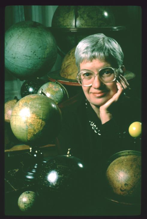 Portrait of Vera Rubin surrounded by her collection of globes. 