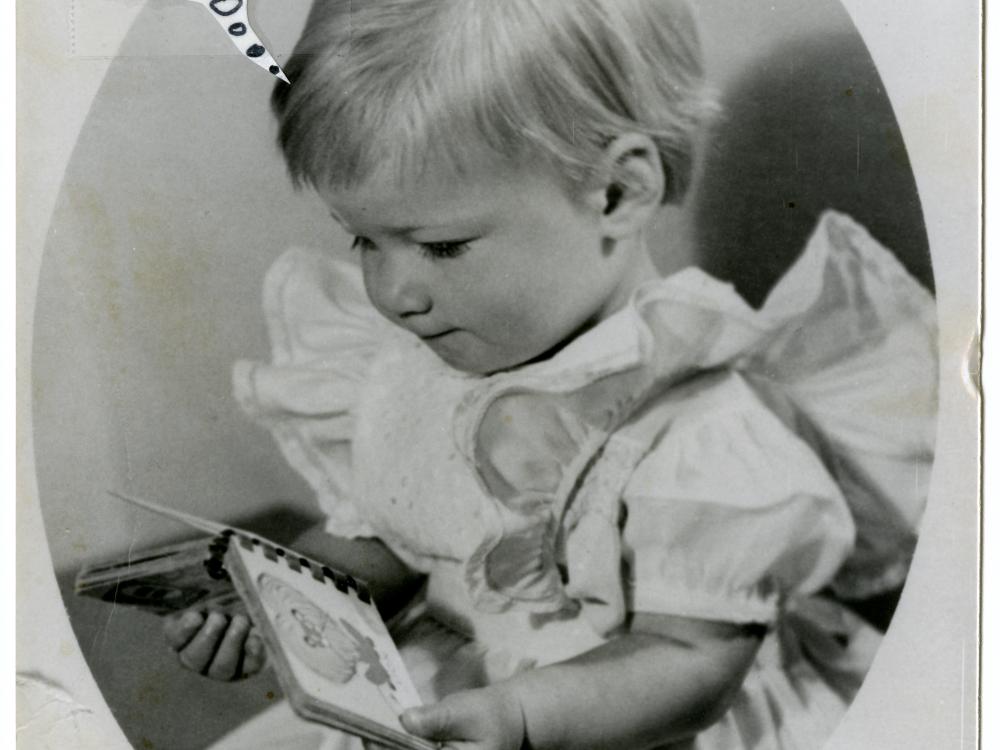 Portrait of Sally Ride as a young child. She is looking at a pocket book. The portrait features a thought bubble caption of technical notes.