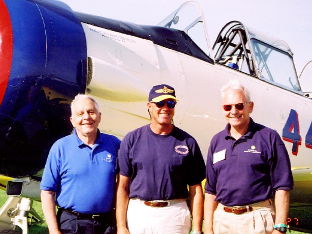 [left to right] Don Lopez, Dale Snodgrass, and Jack Dailey standing next to an aircraft