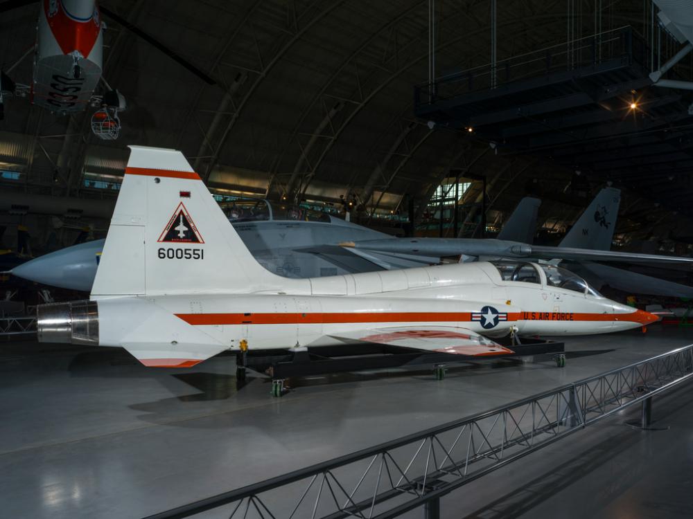 Rear view of a white and orange painted airplane in the museum hangar. 