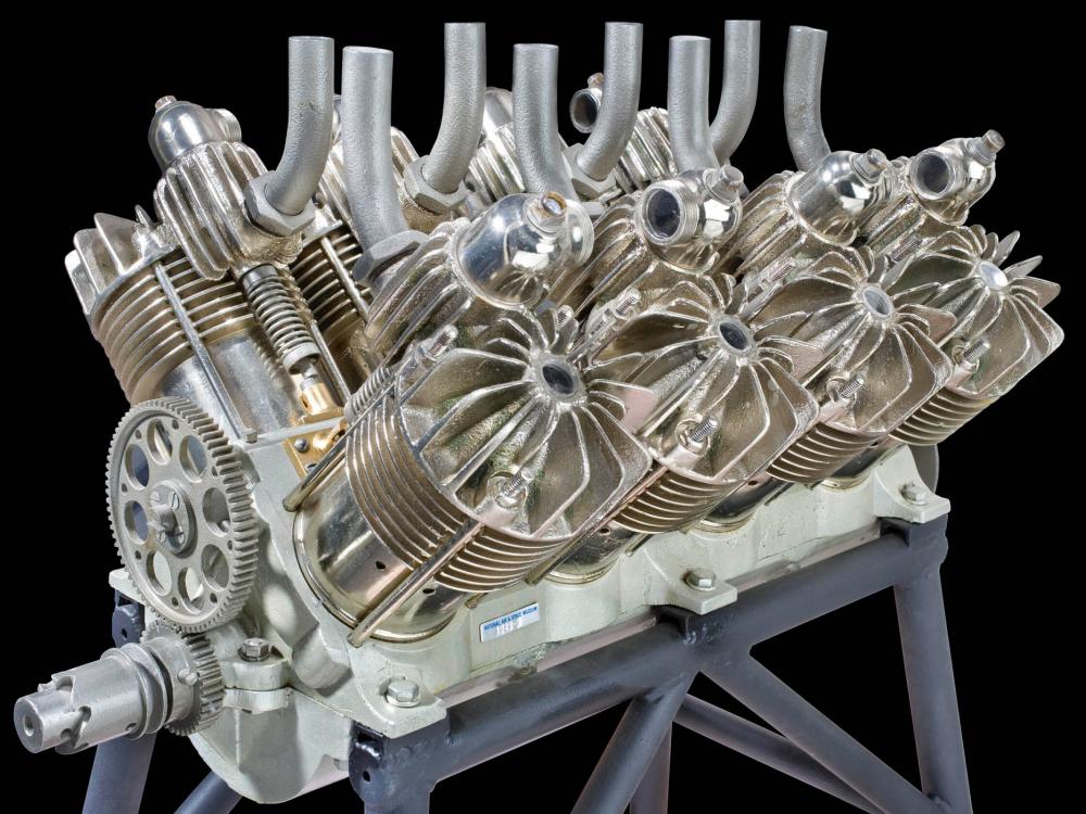 Reciprocating, V-type, 8 cylinder, air-cooled silver colored engine on a black background.