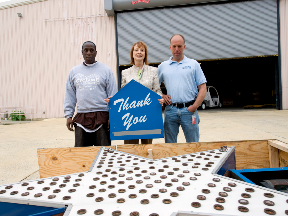 Three Smithsonian staffers stand by the Astroland star holding the "thank you" sign.