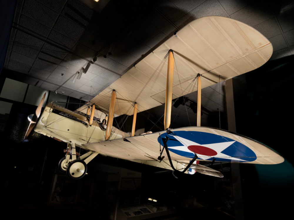 A picture of a beige biplane with a star in a circle on the wing. 