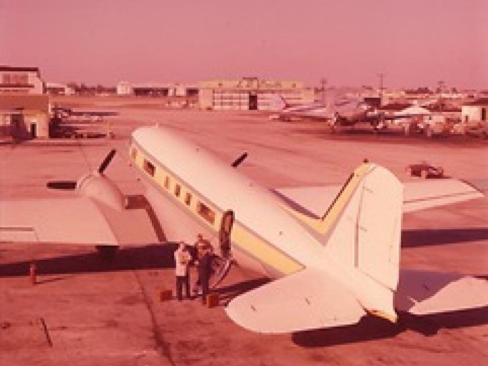 A photo taken from behind the tail of the plane, providing a three-fourths view of the plane from behind. The plane looks similar to a commercial airliner.