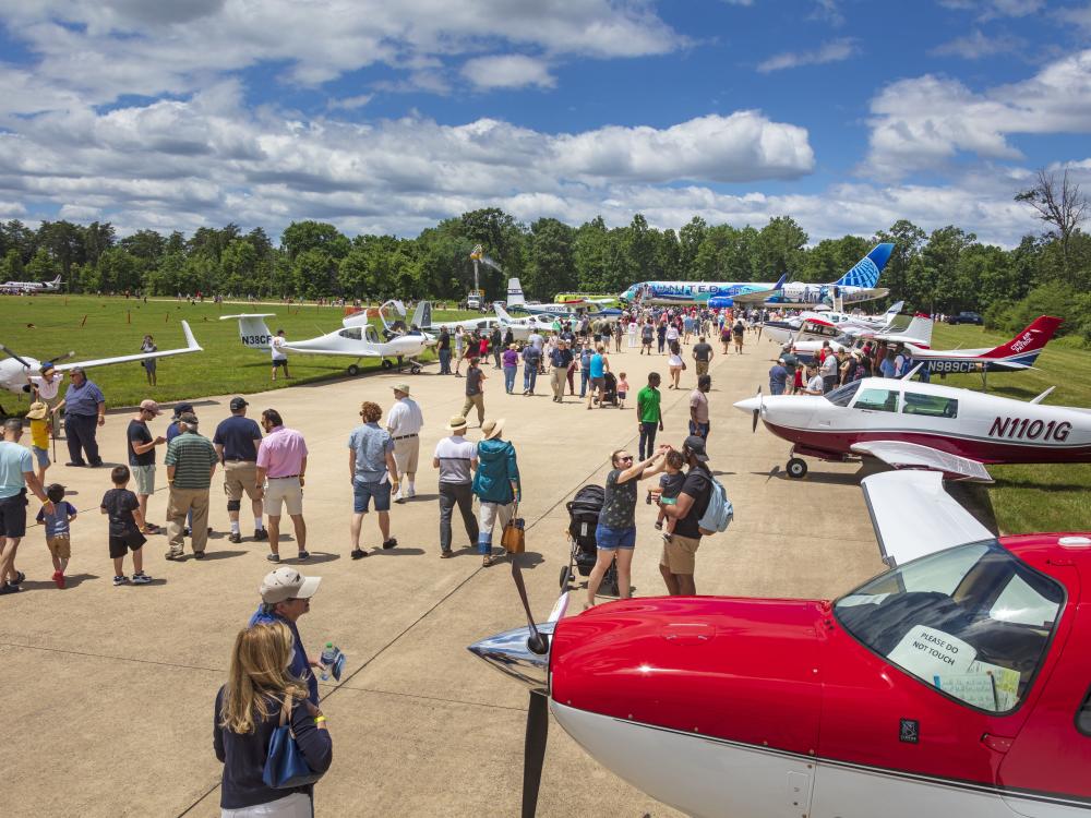 People admire planes parked outside the Museum. The planes taxied over from Dulles Airport. There are a variety of planes, large and small. 