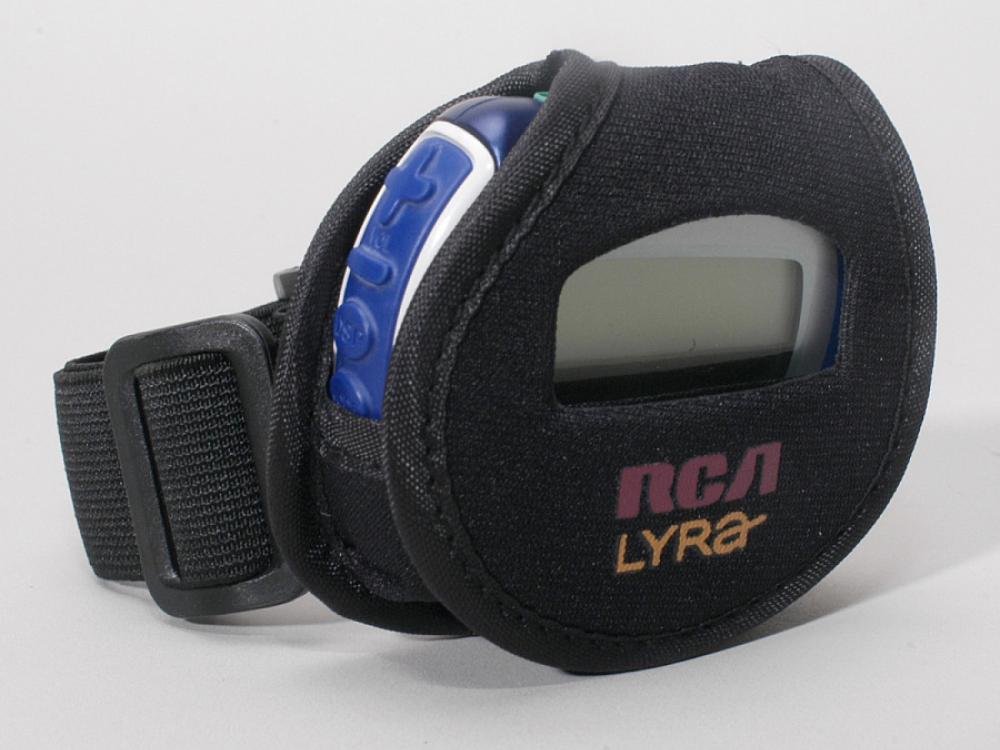 A small circular speaker, which looks similar to a digital watch, in a pouch with a strap.