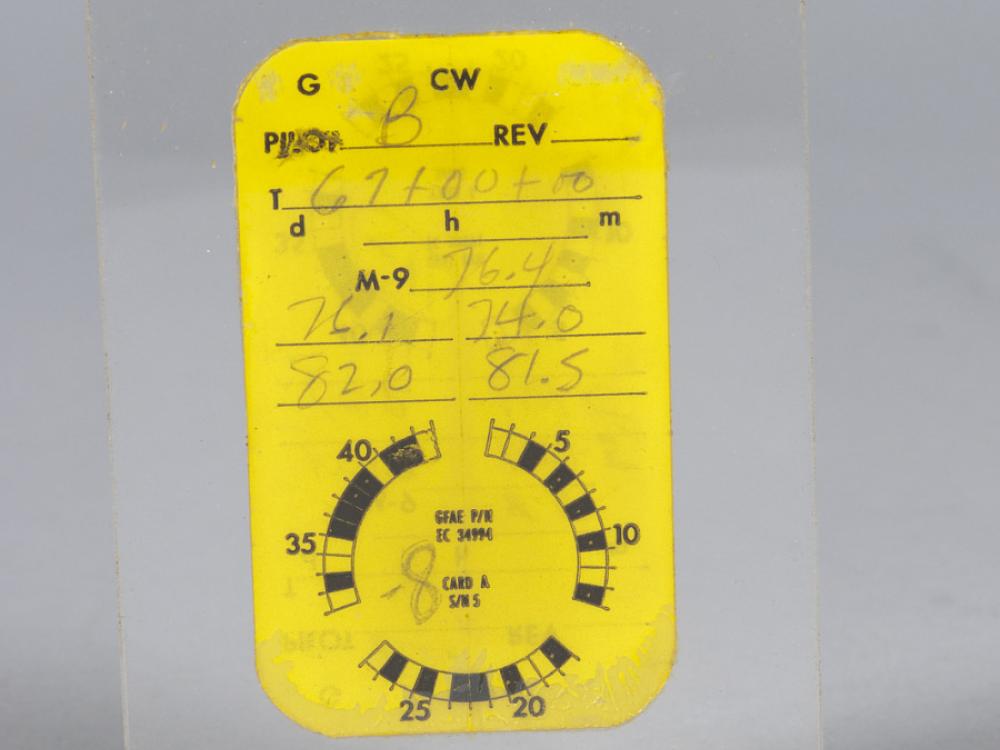 A small rectangular yellow card incased between two pieces of clear plastic. The area at the top of the card denoting the pilot name is marked with a B, presumably for Frank Borman. The rest of the card has different numbers recorded related to different optical measurements.