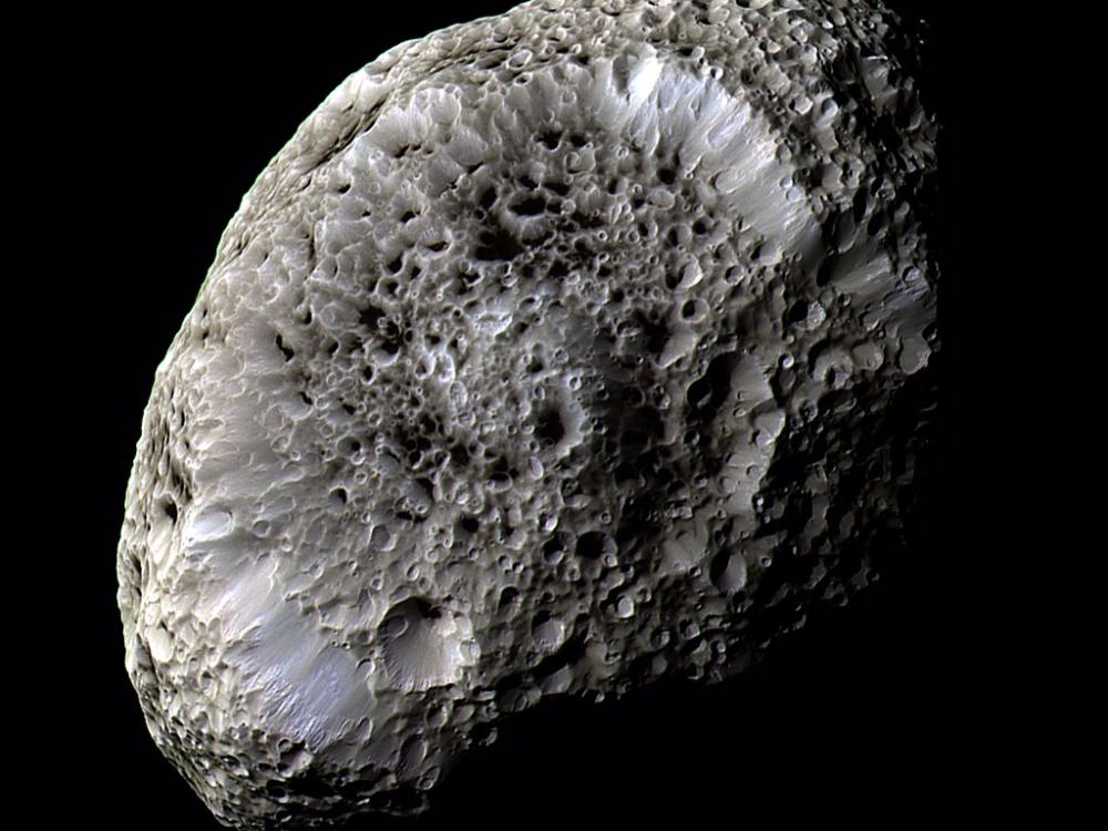 An oval shaped asteroid covered in crater marks.