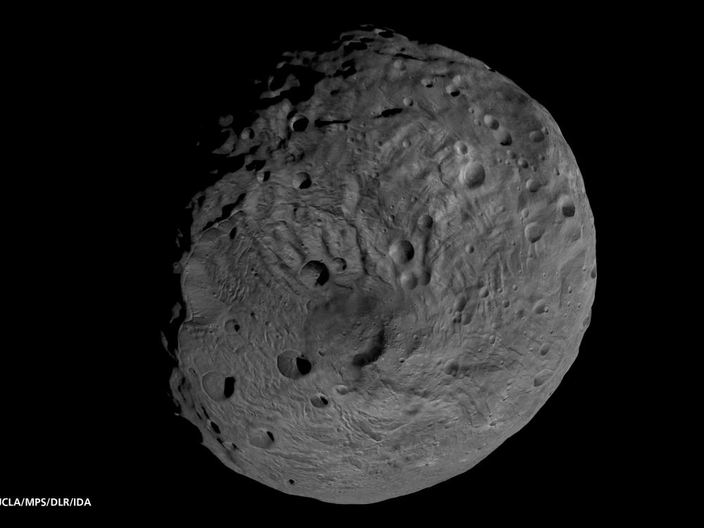 A globe shaped asteroid with a cratered surface. 