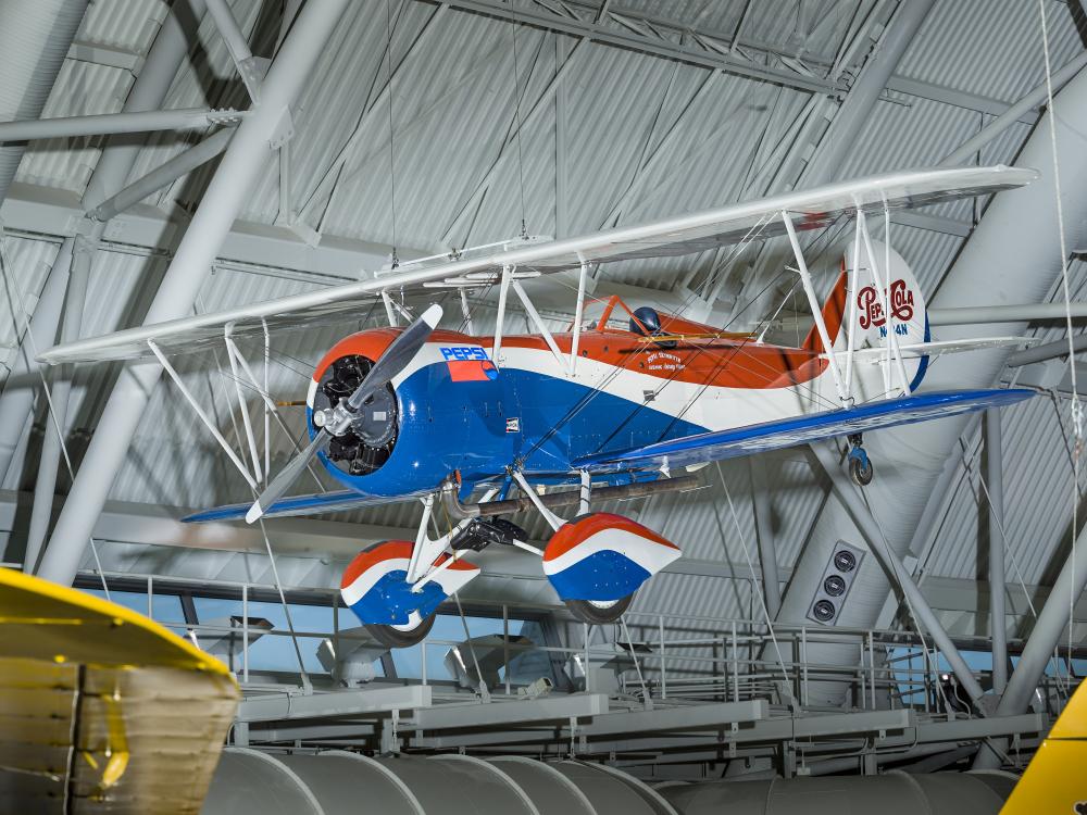 Red white and blue biplane with Pepsi-Cola logo on the back