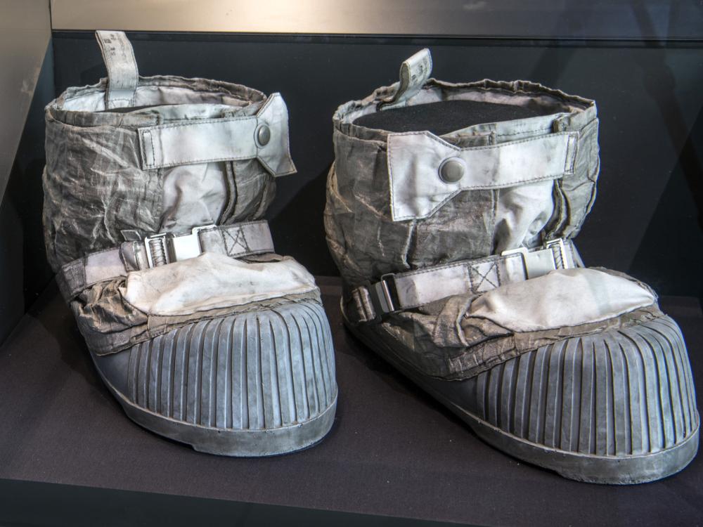 A pair of space boots are on displayed in an enclosed case