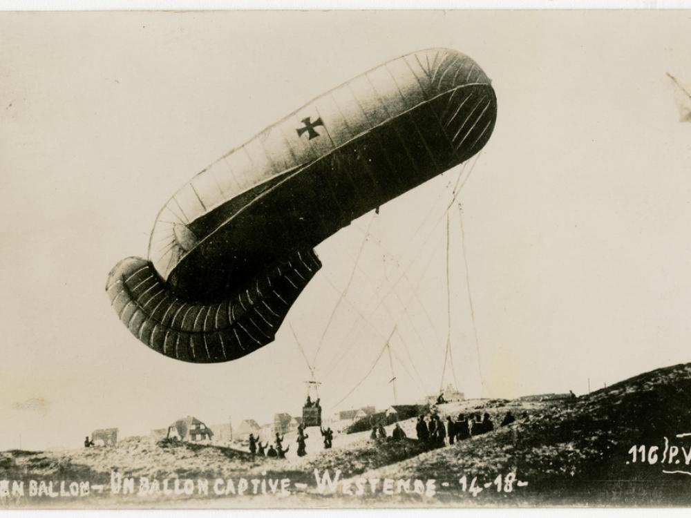 A balloon being pulled down by a group of people.