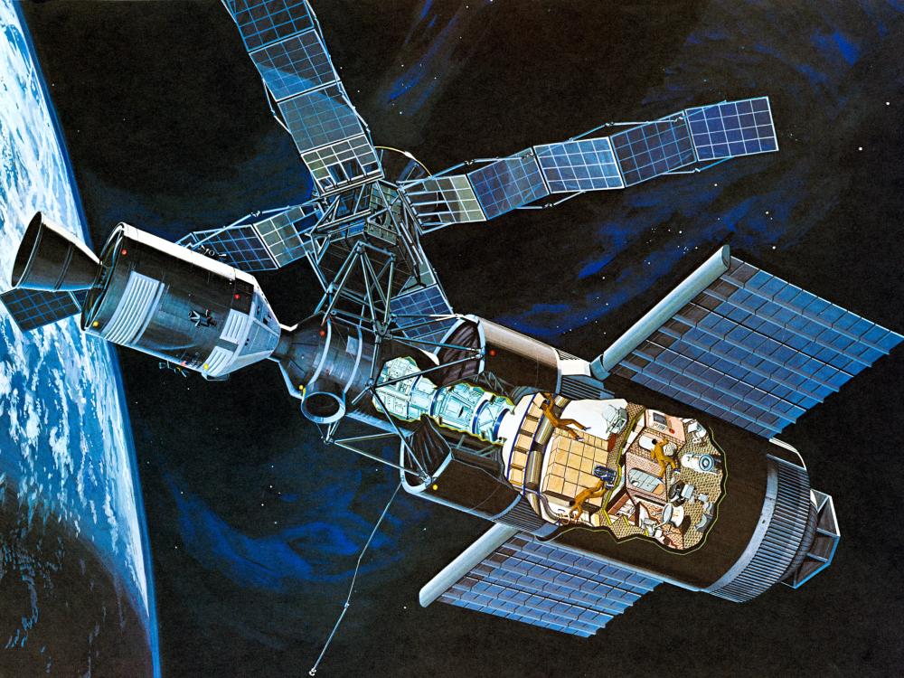 An illustration in an orbital workshop, with a cutaway showing astronauts working inside.