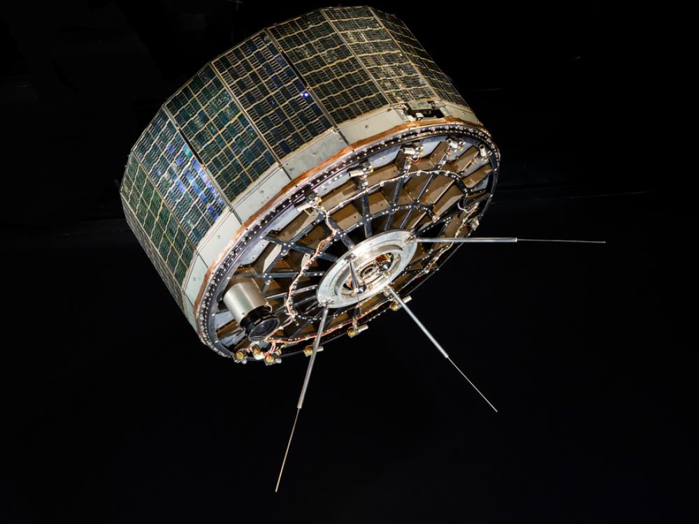 A stout cylindrical satellite with panels on the outside. 