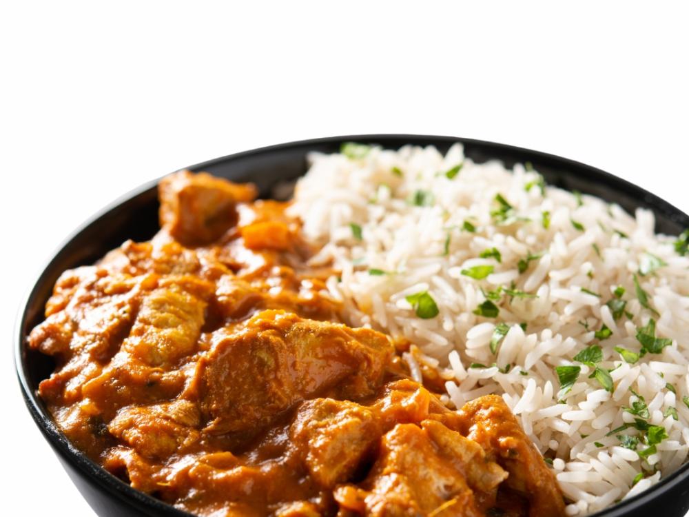 A bowl with chicken in sauce and rice.