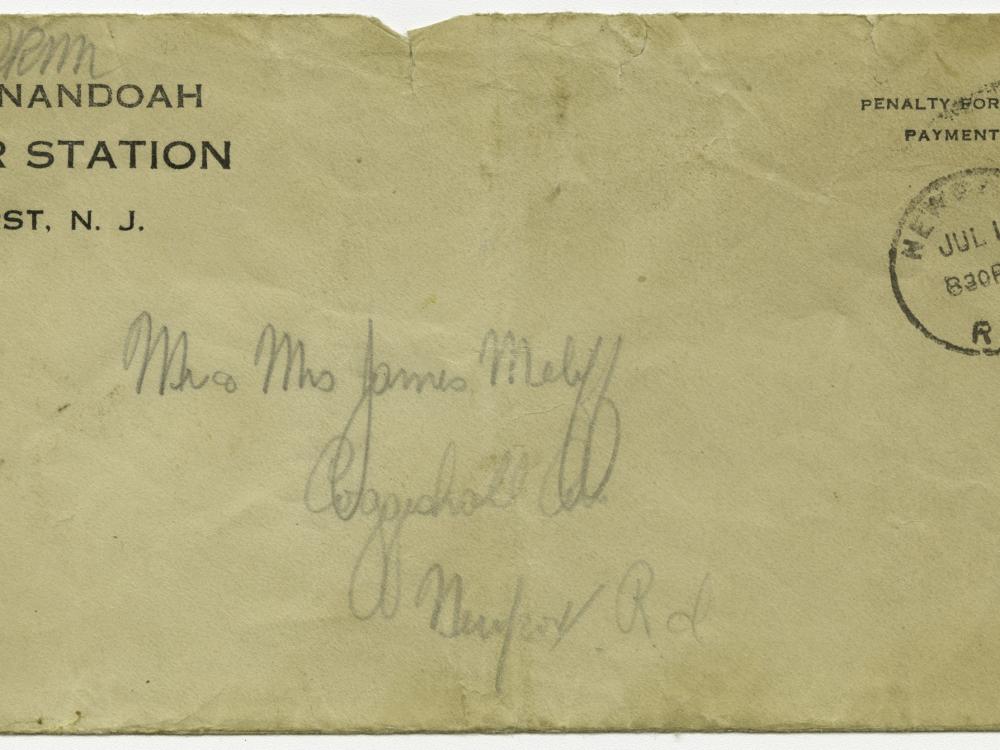 A weathered addressed envelope with a stamp in the upper righthand corner and the words USS Shenandoah, Naval Air Station, Lakehurst, N.J. in the upper lefthand corner.