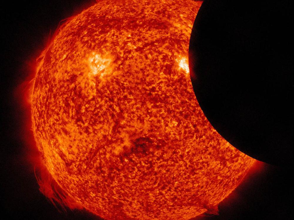 A close up photo of the sun with something round obscuring the right part. 