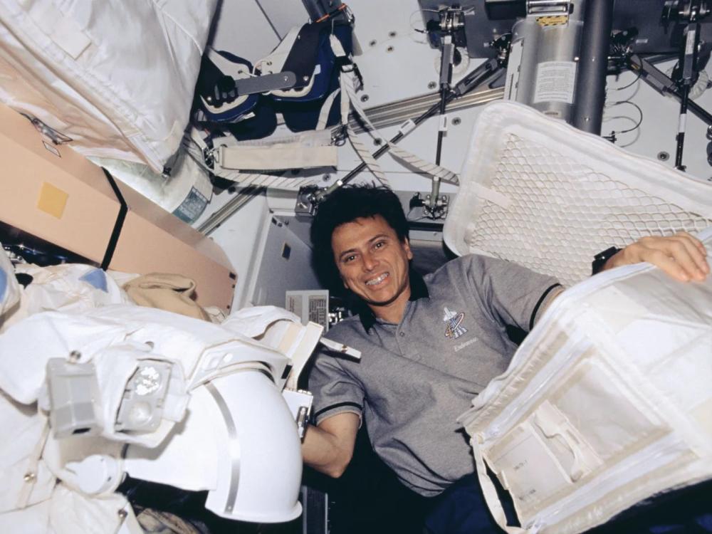 An astronaut floats in zero gravity inside of a space vehicle without a spacesuit.