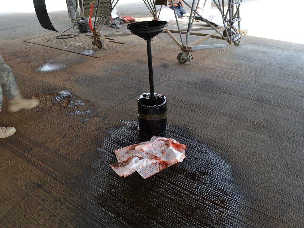 A device is on top of oil on a pavement.