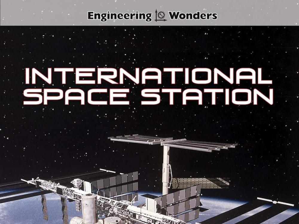Children's book cover with the title International Space Station. There is a photograph image of a large space station floating above Earth in outer space.