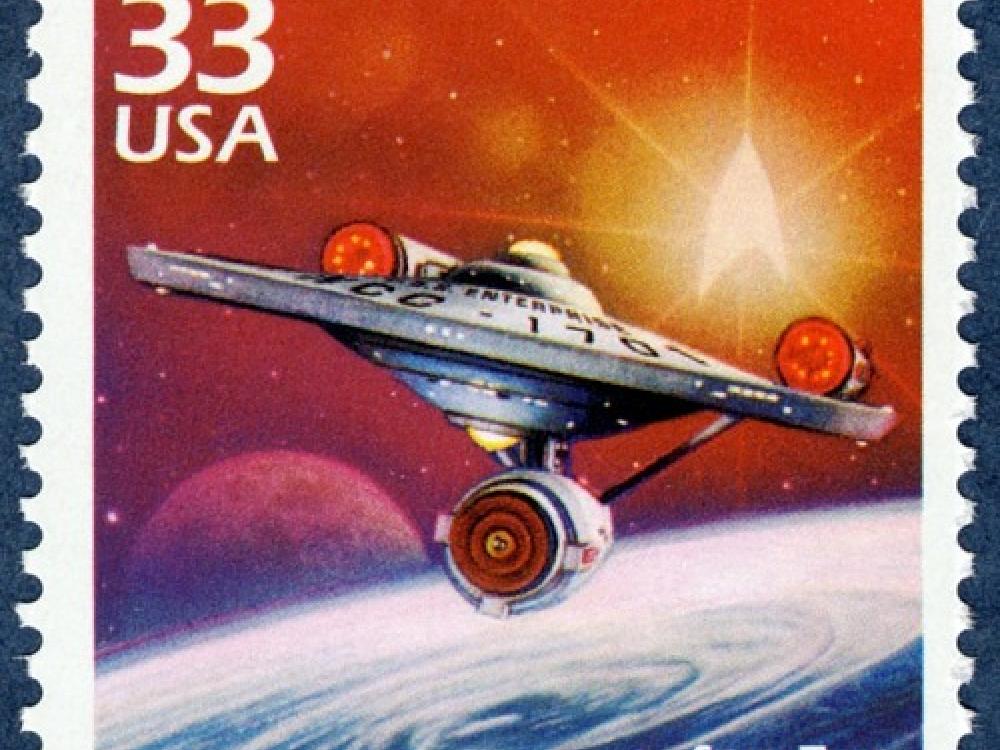 An illustration of the saucer shaped starship Enterprise from Star Trek flying through space adorns a stamp that says "33 USA" in the upper lefthand corner.