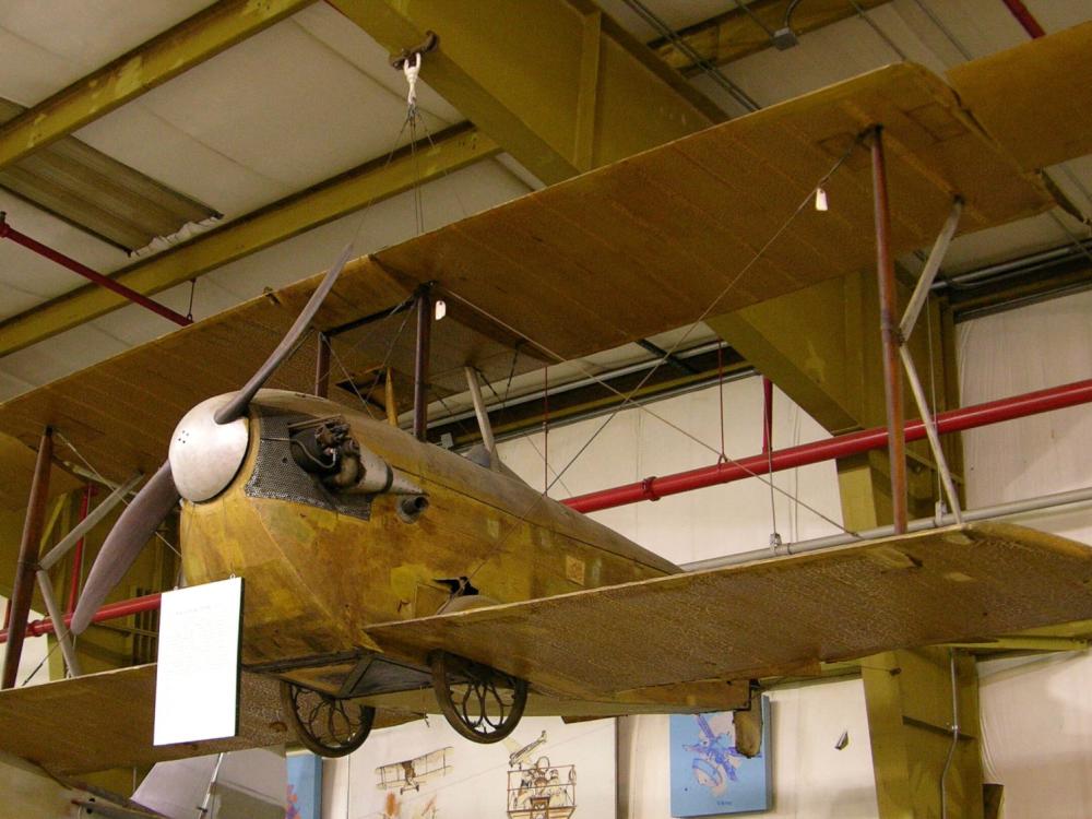 K-III airplane hangs from the ceiling inside a facility.