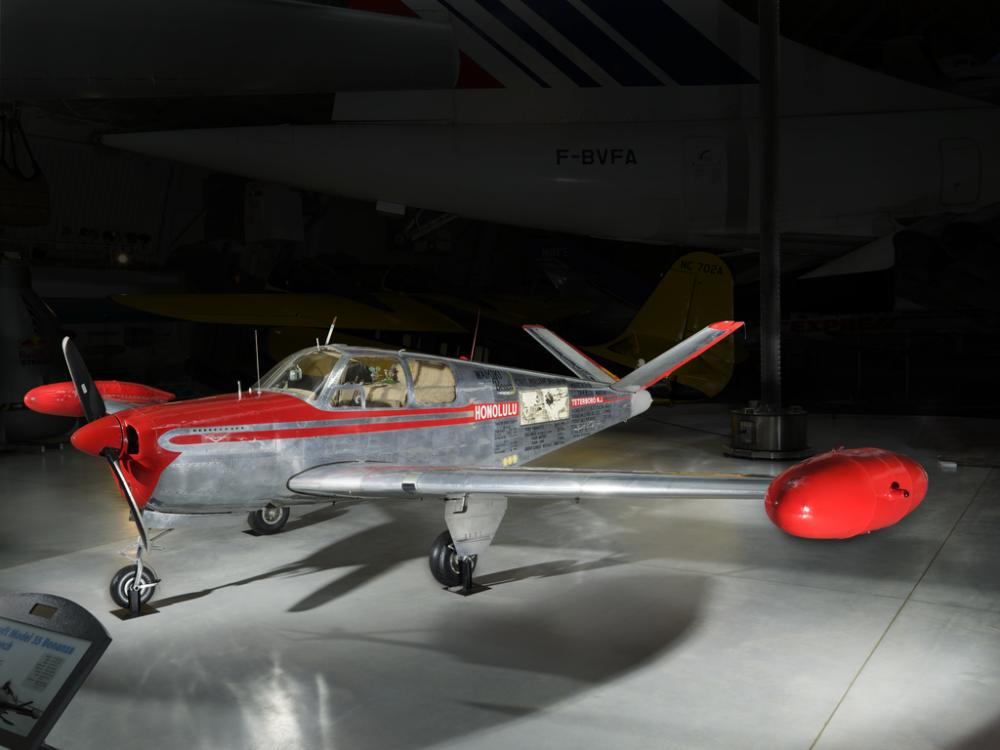 Silver and red painted single engine aircraft with four seats.