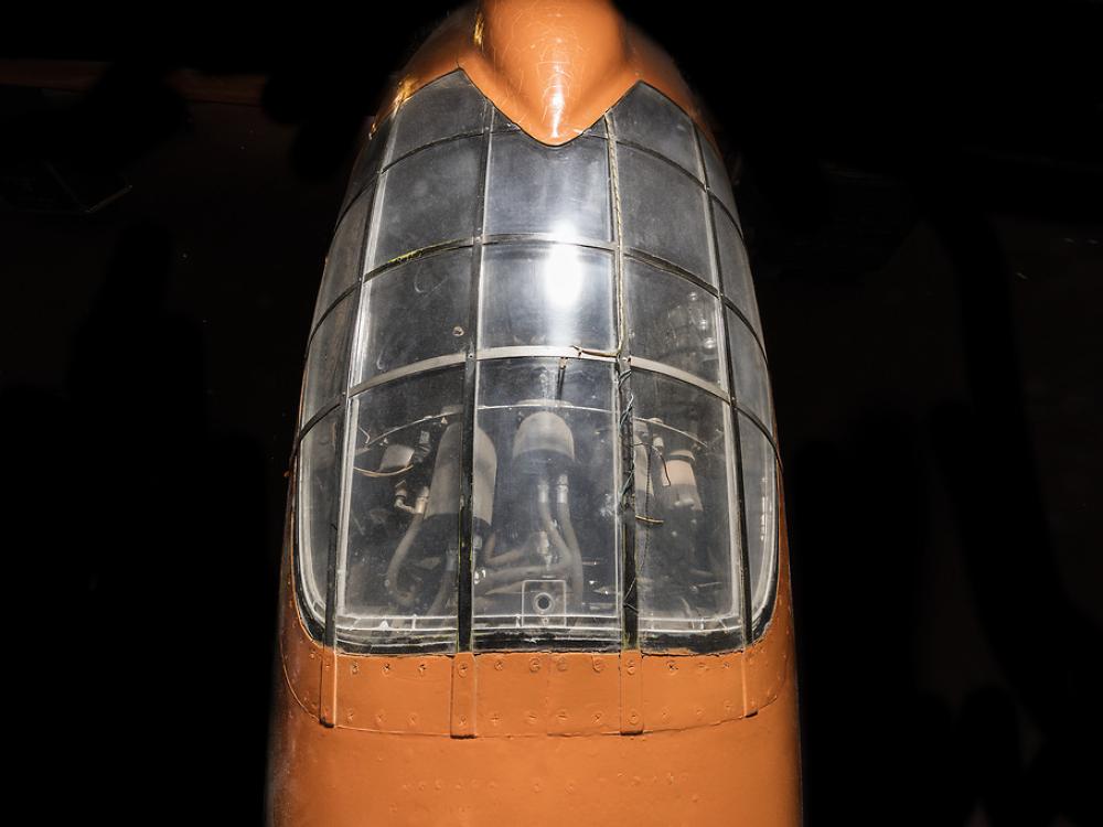 Top view of cockpit of an airplane. The airplane is painted orange and the cockpit window is closed. 